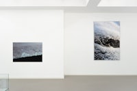 a white room with three paintings on the wall