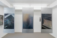 three photographs hanging from a wall in an art gallery