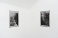 two black and white photographs hanging on a white wall