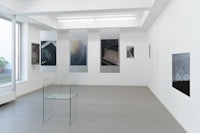 an empty room with several paintings on the wall