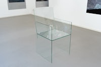 a chair made of glass in an art gallery